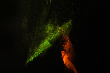 Freeze motion of colorful dust explosion on black background for Happy Holi