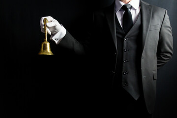 Portrait of Butler in Dark Formal Suit and White Gloves Holding Gold Bell. Professional Hospitality and Courtesy. At Your Service. - obrazy, fototapety, plakaty