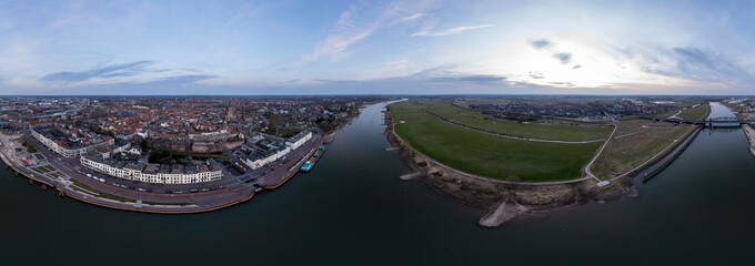 Colorful aerial cityscape of tower town Zutphen ready for use in VR surrounding. 360 degrees panorama of medieval city seen from across the river IJssel passing the white countenance facades.