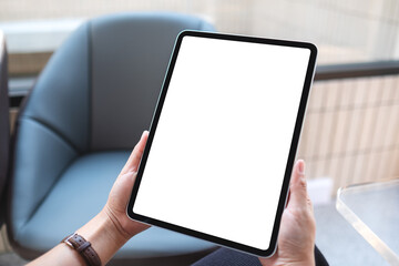 Mockup image of a woman holding digital tablet with blank white desktop screen in cafe