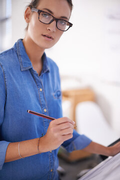 Paying Attention To Detail. Shot Of An Attractive Architect Working On Blueprints.