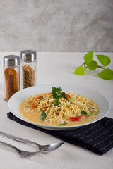 a bowl of hot noodle with boiled egg, chicken, slice chili in white bowl on white background texture