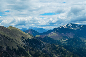 Naklejka na ściany i meble Panoramic view from Frauenkogel on mountain peaks in the Karawanks and Julian Alps, Carinthia, Austria. Borders Austria, Slovenia, Italy. Triglav National Park. Alpine meadows in spring. Woodland