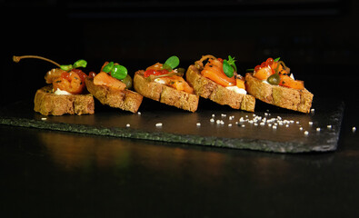 Sandwiches or tapas of bread red caviar and red fish with micro greens, seafood Luxury delicacy food