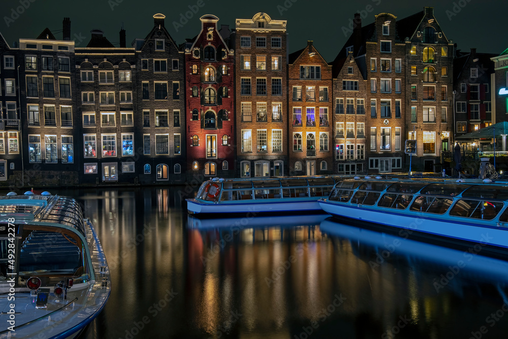 Canvas Prints traditonal houses and cruise boats at the damrak in amsterdam in the netherlands by night