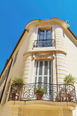 Fototapeta na wymiar Building with french windows and balcony in typical architecture style for France 