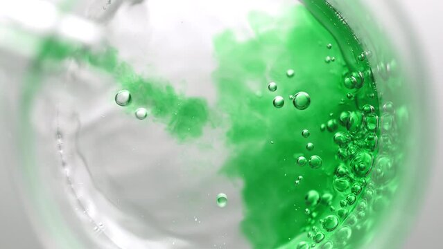 Green Liquid Pouring Into Beaker With Water Creates Bubbles