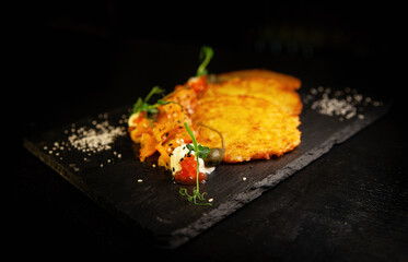Potato fritter pancake with red caviar, salmon in luxury restaurant
