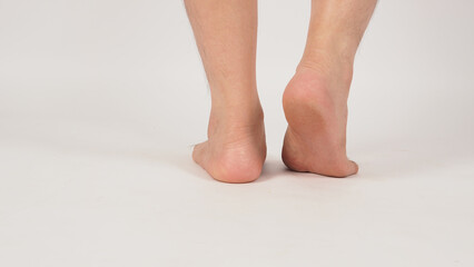 Asian Male barefoot is standing and one heel lift isolated on white background.Shot from behind
