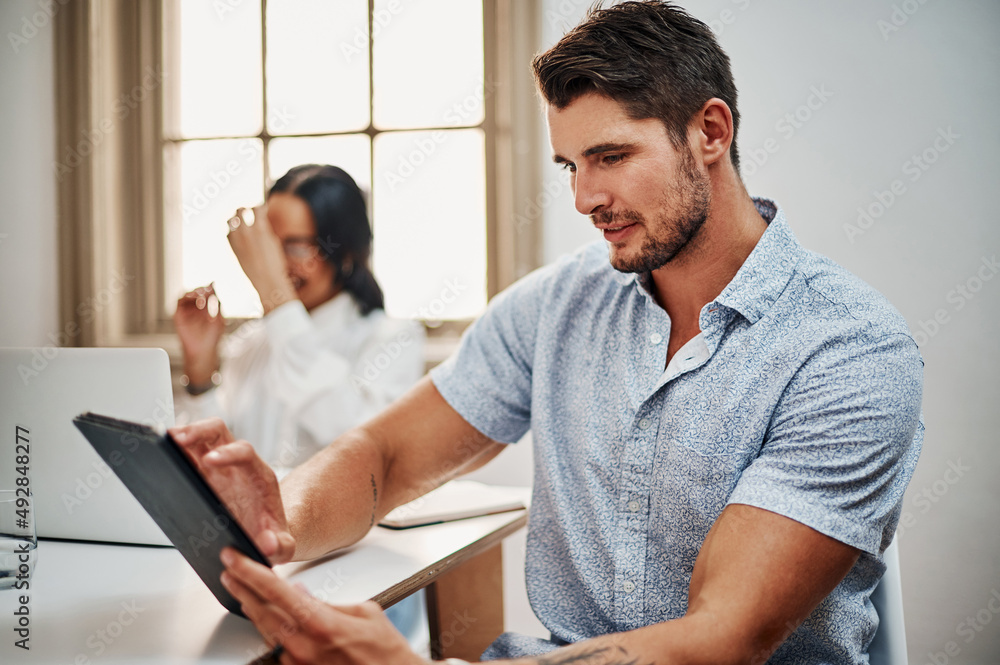 Poster a must have device for any modern meeting. shot of a young businessman using a digital tablet during