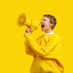 a girl in yellow clothes screams into a yellow megaphone. alarm