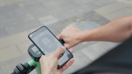 Man rent an electric scooter. motorized scooter is a powered stand-up scooter using a small electric motor. Payment for rental using a smartphone via a mobile application