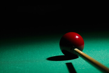 Man playing billiard sport game, red ball and cue minimal background, copy space for text