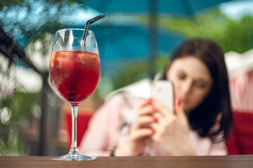 Cocktail close up on the background of a girl in a cafe