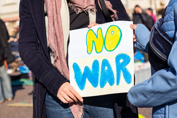 Woman with mother holding a poster: no war in a square in Germany, demonstration in Potsdam