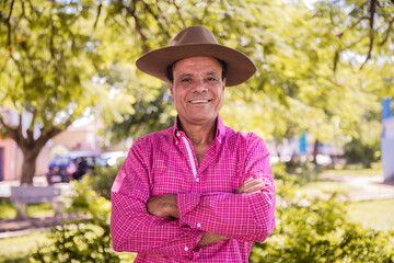 Portrait of smiling handsome older male farmer. Elderly farmer with arms crossed smiling looking at camera