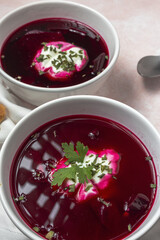 Traditional Ukrainian and Russian national red borscht soup en bol with sour cream and herbs