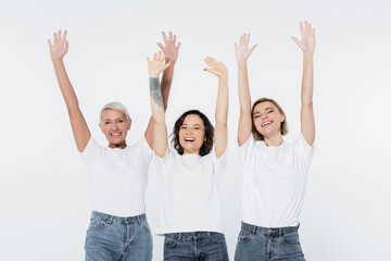 Cheerful women waving hands and looking at camera isolated on grey.