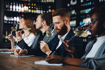 Sommeliers male and african woman hold glass red wine tasting degustation card