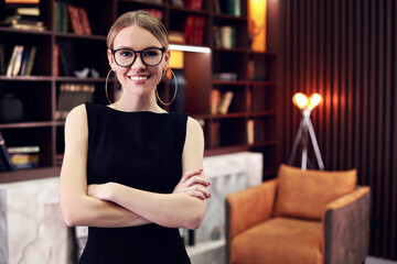 Stylish elegant woman in glasses in modern office. Crossed hands. Modern University library.
