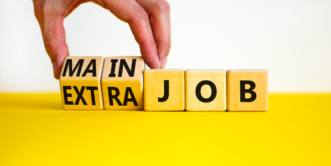 Extra or main job symbol. Businessman turns wooden cubes and changes concept words Extra job to...