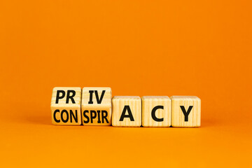 Privacy or conspiracy symbol. Turned wooden cubes and changed the word Conspiracy to Privacy. Beautiful orange table orange background. Business privacy and conspiracy concept. Copy space.