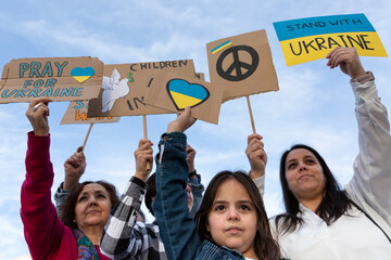 Group of people with raised banners demonstrating against the war in Ukraine. Activism and human rights movement.