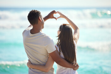 Our love runs deeper than the ocean. Shot of a young couple making a heart gesture with their hands...
