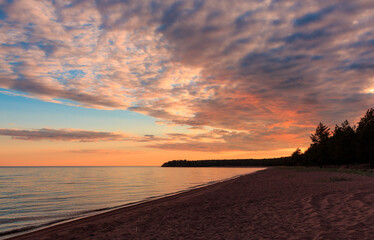 Sunset in Karelia, on Lake Ladoga, in the foreground there are stones on the back.