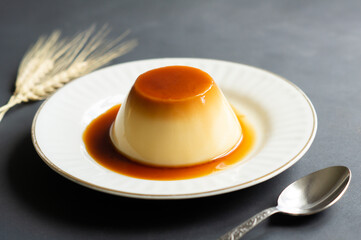 Cream caramel pudding with caramel sauce in plate on rustic table