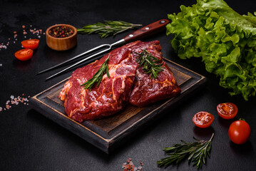 Raw organic marbled beef steaks with spices on a wooden cutting board