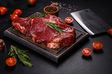 Fototapeta na wymiar Raw organic marbled beef steaks with spices on a wooden cutting board