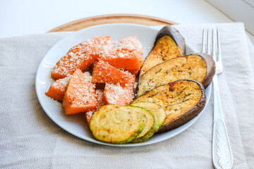 Grilled vegetables baked in the oven with Parmesan cheese on textile napkin. Pieces of pumpkin, eggplant, Aubergine and zucchini with Parmesan. Healthy vegan organic meal. Superfood for immune system.