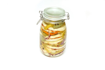 Several camembert type cheeses, onion and peppers pickled in the vegetable oil in a glass bottle. Isolated in a white background. 