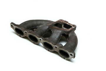 The used and rusty cast iron car engine air intake manifold isolated in a white background. 