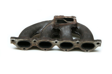 The used and rusty cast iron car engine air intake manifold isolated in a white background. 