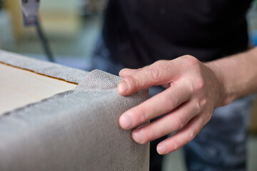 Carpenter checks the quality of the upholstery of the upholstered furniture frame. Inspection and...