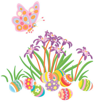 Spotted merry butterfly flittering over colorfully painted Easter eggs among spring wildflowers, vector cartoon illustration isolated on a white background