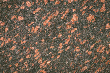 Red granite texture. A variegated, spotted background of red (brown) granite. The stone granite...