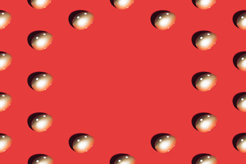 Pattern made of golden eggs on red background. Minimal Easter or food concept. Copy space.