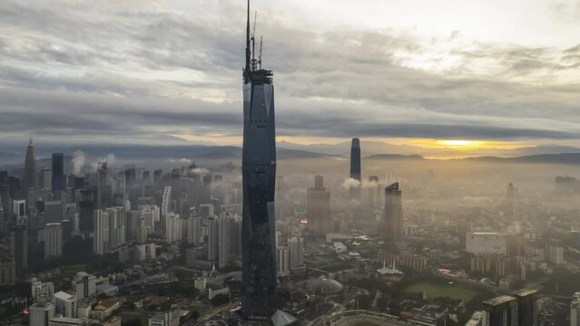 Aerial time lapse (hyperlapse) cinematic shot at Kuala Lumpur city skyline during sunrise. Zoom in