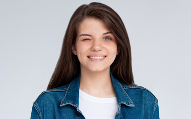 Close-up of cute and dreamy young woman smiling, winking at camera to encourage client, standing...