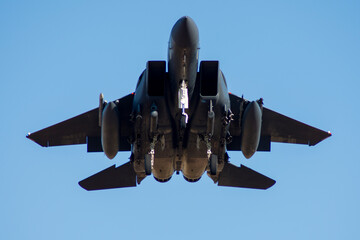 Vista frontal de avión de combate bimotor aterrizando F-15