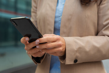 Business woman using phone to send sms outdoor closeup