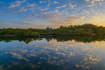 Sunrise waterscape with scattered clouds and reflections