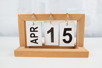 April 15, wooden calendar on a white table.