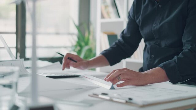 Video of close-up of smart architect hands working and drawing with pen over diagram on paper in the office.