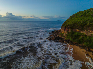 Aerial sunrise seascape with sea foam and low cloud bank