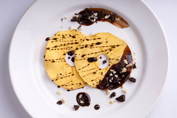 Dried apples with nuts and chocolate on a white plate