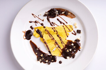 Dried pineapples with nuts and chocolate on a white plate